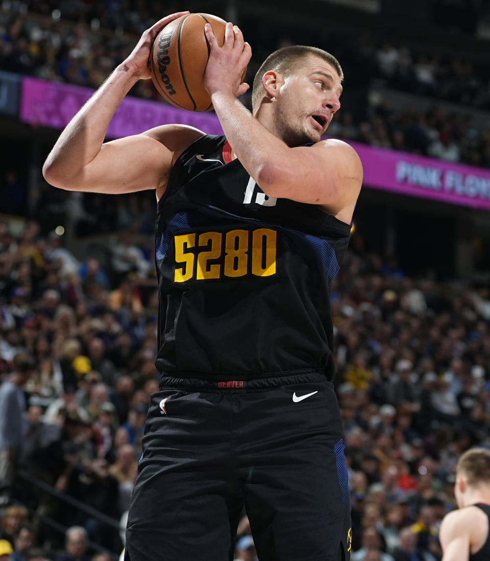 Denver Nuggets center Nikola Jokic pulls in a rebound during the first half of the team's NBA basketball game against the Phoenix Suns on Wednesday, March 27, 2024, in Denver. (AP Photo/David Zalubowski)