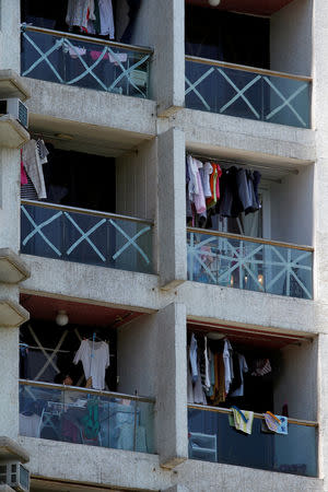 A man hangs clothes at a flat with glasses taped, in preparation for Typhoon Mangkhut in Hong Kong, China September 15, 2018. REUTERS/Bobby Yip