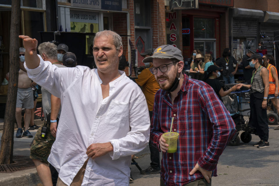 This image released by A24 shows Joaquin Phoenix, left, and director Ari Aster on the set of "Beau is Afraid." (Takashi Seida/A24 via AP)