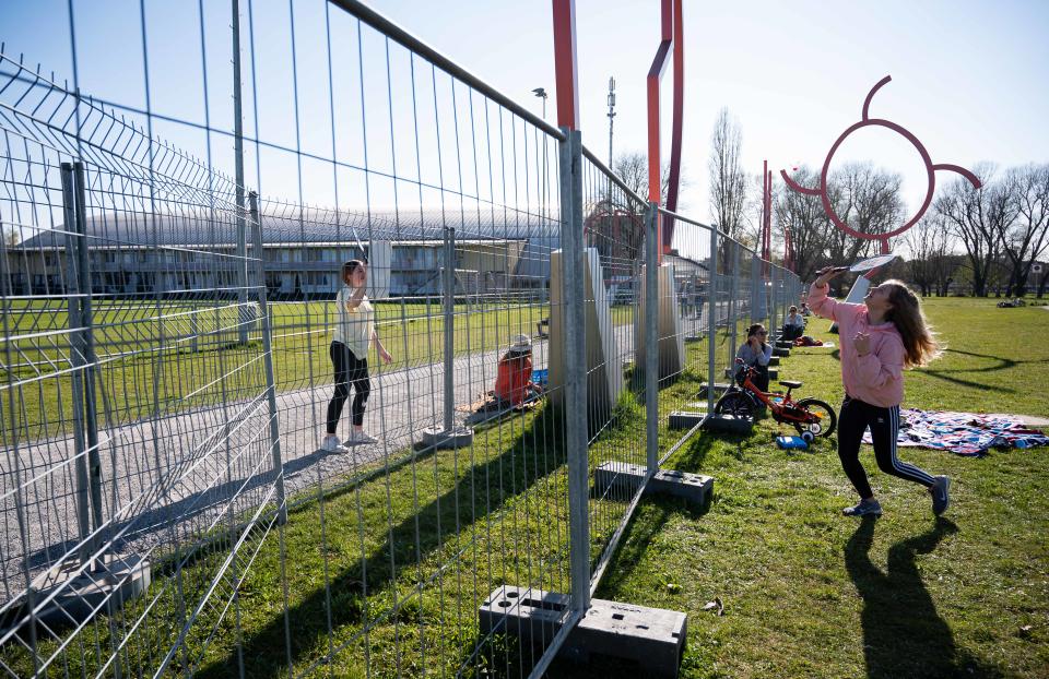 KONSTANZ, GERMANY - APRIL 06: Two girls play badminton from two fences in order to stop physical contact along the Germany-Switzerland border during the coronavirus crisis on April 6, 2020 in Konstanz, Germany. Cross-border travel has been temporarily banned in an effort to stem the spread of the virus. Authorities recently added the double fence at Konstanz in order to prevent lovers, of which one lives in Germany and the other in Switzerland, from meeting there and hugging. Many people who live on the Germany side of the border work in Switzerland. (Photo by Daniel Kopatsch/Getty Images)