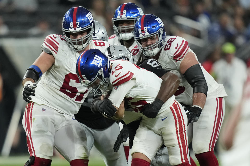 Las Vegas Raiders defensive tackle Adam Butler sacks New York Giants quarterback Tommy DeVito (15) during the second half of an NFL football game, Sunday, Nov. 5, 2023, in Las Vegas. (AP Photo/John Locher)