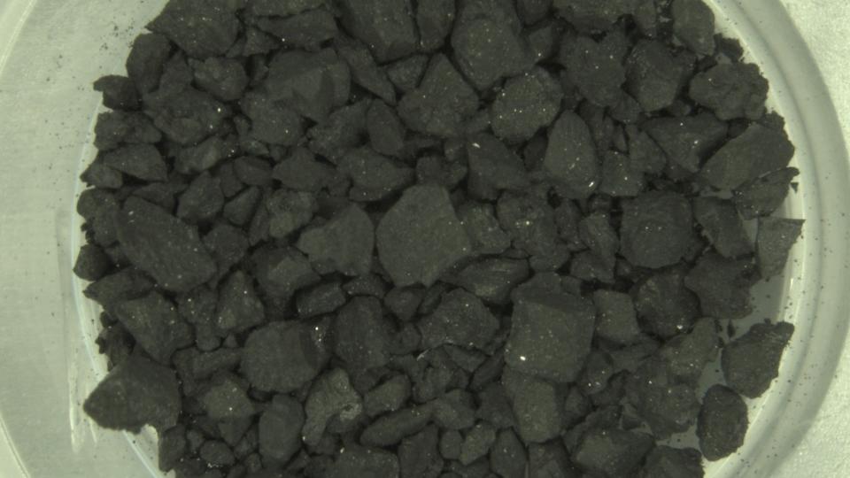  dark rocks in a white container 