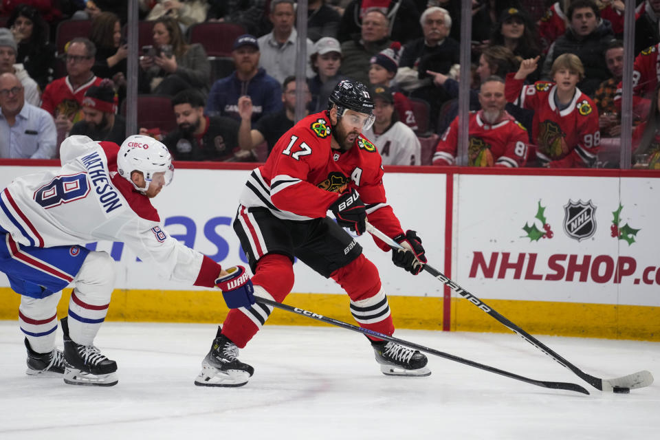 Montreal Canadiens defenseman Mike Matheson, left, reaches for the puck as Chicago Blackhawks left wing Nick Foligno controls it during the second period of an NHL hockey game Friday, Dec. 22, 2023, in Chicago. (AP Photo/Erin Hooley)