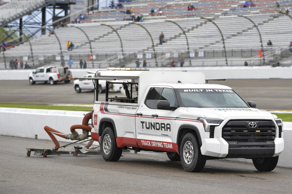 A truck from the track drying team helps dry pit road before the start of the NASCAR Xfinity Series auto race at Richmond Raceway, Saturday, April 1, 2023, in Richmond, Va. (AP Photo/Mike Caudill)