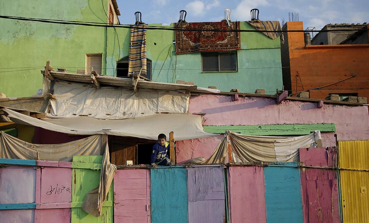 A Palestinian boy climbs on a painted wall in the Shati refugee camp in Gaza City in 2015. <a href="https://images.squarespace-cdn.com/content/v1/57cf18ae6b8f5ba693497e1a/1474043441471-IU9GCH5Y6Z8XP9M8EYQJ/ap_63282323864.jpg?format=2500w" rel="nofollow noopener" target="_blank" data-ylk="slk:AP Photo/Hatem Moussa;elm:context_link;itc:0;sec:content-canvas" class="link ">AP Photo/Hatem Moussa</a>