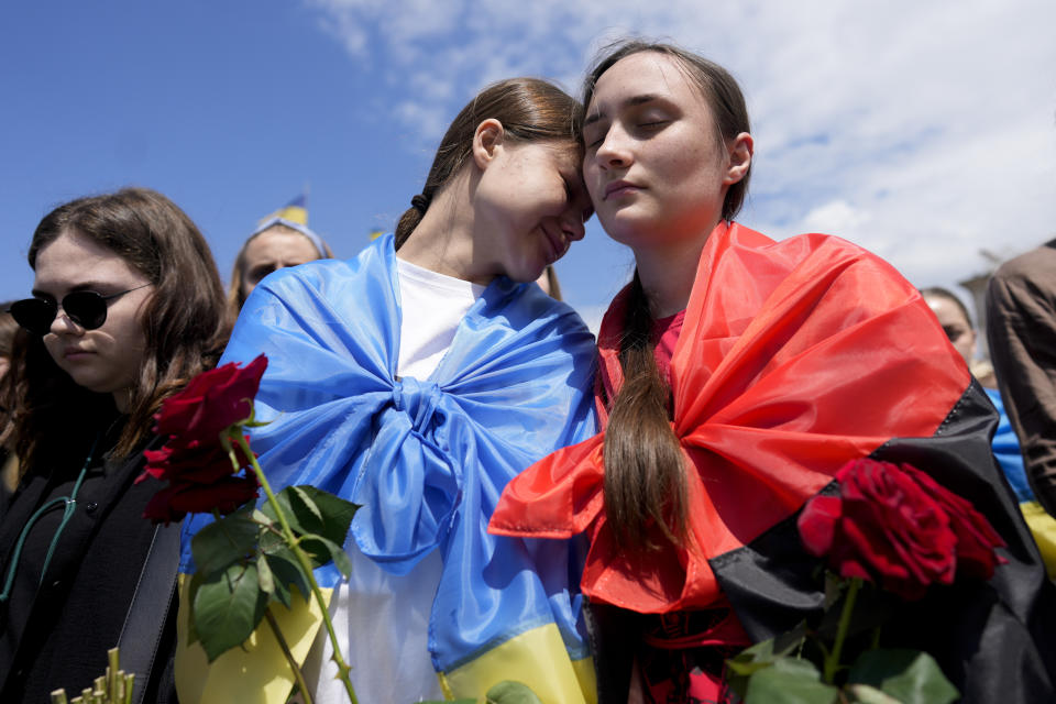 CAPTION CORRECTS FAMILY NAME OF SOLDIER Women attend a memorial service of activist and soldier Roman Ratushnyi at Maidan square in Kyiv, Ukraine, Saturday, June 18, 2022. Ratushnyi died in a battle near Izyum, where Russian and Ukrainian troops are fighting for control the area. (AP Photo/Natacha Pisarenko)