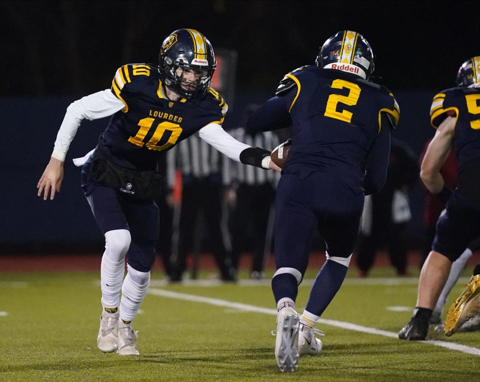 Lourdes' Mike Sabini hands the ball off during a Class A state quarterfinal on Nov. 18, 2022.