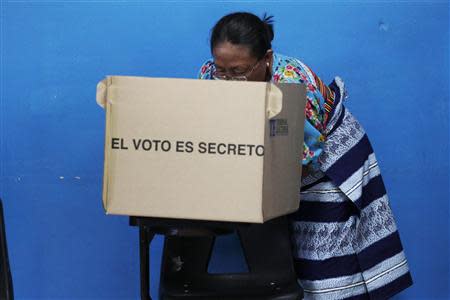 An indigenous Guna woman writes her ballot for presidential election at a polling station outside Panama City, May 4, 2014. REUTERS/Edgard Garrido