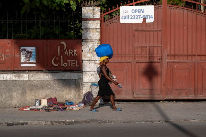 A woman walks on a sidewalk following the assassination of President Jovenel Moise