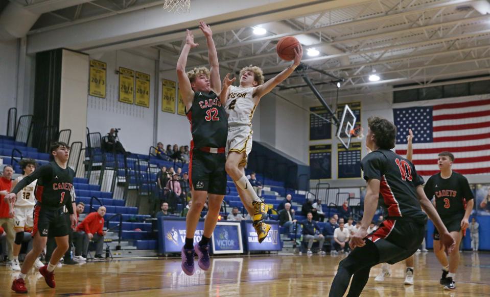 Victor's Griffen Hopkins drives in to score as Hilton's Benjamin Sneddon defends the lane in the first quarter during their Section V matchup Wednesday, Jan. 10, 2024 at Victor High. Victor won the game 77-63.