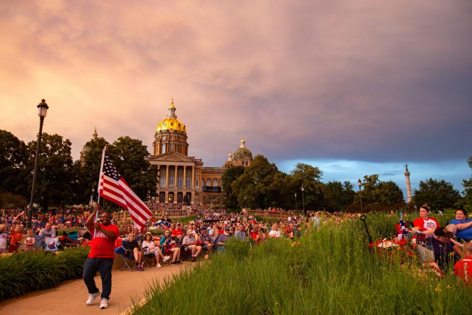 Jermaine Simmons of Des Moines waves the flag as thousands attend the Des Moines Symphony's 26th annual Yankee Doodle Pops on the Capitol grounds Wednesday, July 3, 2019, the last year the event was held before the COVID-19 pandemic prompted a two-year hiatus.