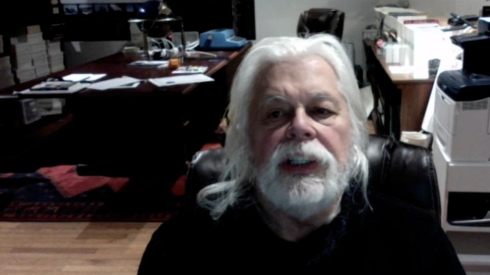 A screenshot of Paul Watson on Zoom. His office can be seen in the background.