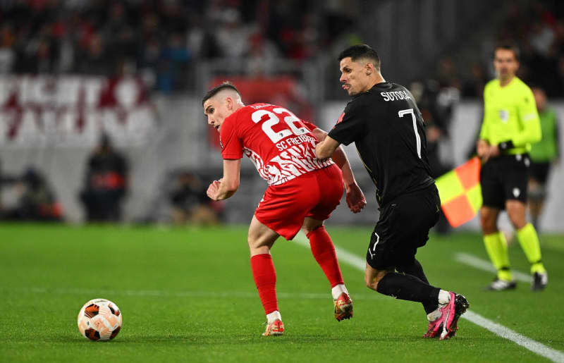 Freiburg's Roland Sallai (L) and Lens' Florian Sotoca battle for the ball during the UEFA Europa League soccer match between SC Freiburg and RC Lens at Europa-Park Stadium. Harry Langer/dpa