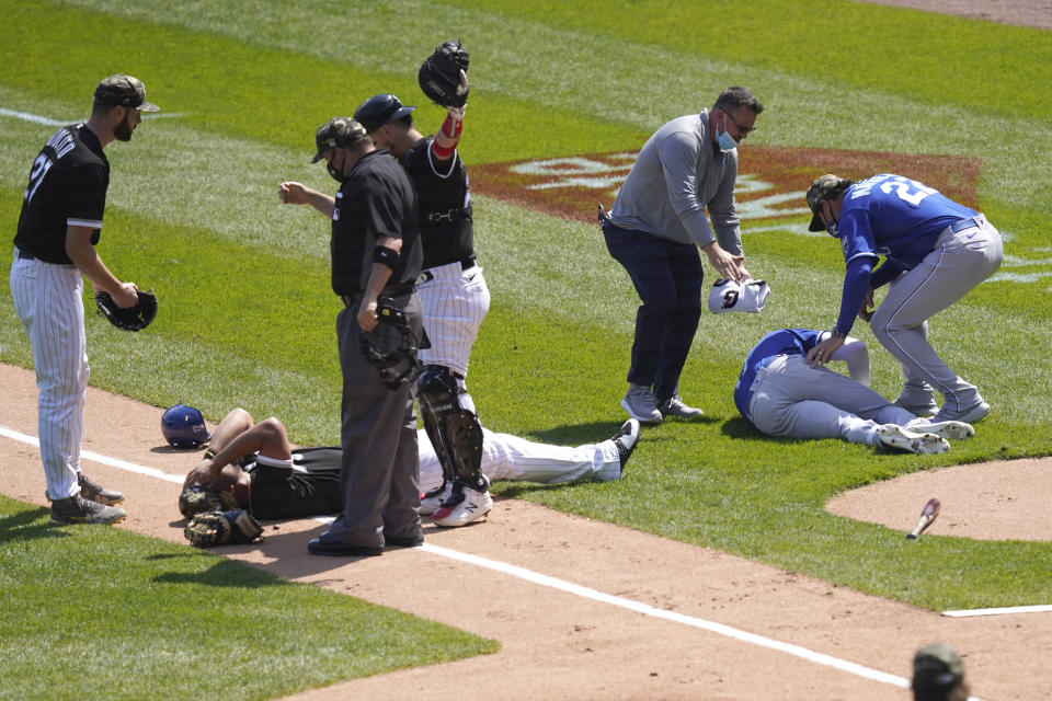 Chicago White Sox's Jose Abreu, left, and Kansas City Royals' Hunter Dozier lay near each other after colliding along the first base line in the second inning of the first game of a baseball doubleheader Friday, May 14, 2021, in Chicago. (AP Photo/Charles Rex Arbogast)