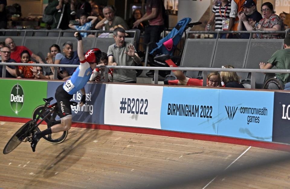 The legs of Matt Walls (ENG) can be seen as he crashes over the barrier into the crowd. Derek Gee (CAN, 15) tries to avoid the barrier during the Mens 15km Scratch race. Commonwealth Games Track Cycling, Olympic Velodrome, Stratford, London, United Kingdom - 31 Jul 2022