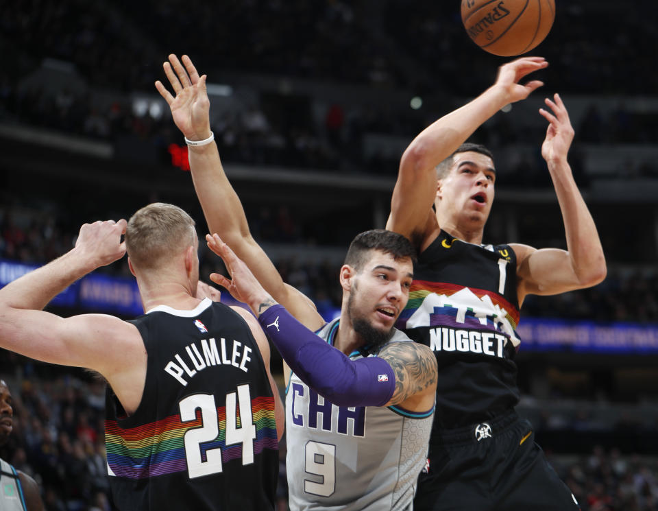 From left, Denver Nuggets forward Mason Plumlee, Charlotte Hornets center Willy Hernangomez and Nuggets forward Michael Porter Jr. look for a rebound ruing the first half of an NBA basketball game Wednesday, Jan. 15, 2020, in Denver. (AP Photo/David Zalubowski)