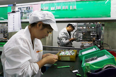 FILE PHOTO: Employees work at a production line of lithium ion batteries inside a factory in Dongguan, Guangdong province, China October 16, 2018. Picture taken October 16, 2018. REUTERS/Joyce Zhou/File Photo