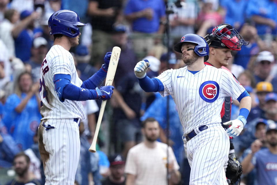 Chicago Cubs' Ian Happ, front right, is greeted at home by Cody Bellinger after hitting a home run off Atlanta Braves relief pitcher A.J. Minter during the seventh inning of a baseball game Saturday, Aug. 5, 2023, in Chicago. (AP Photo/Charles Rex Arbogast)