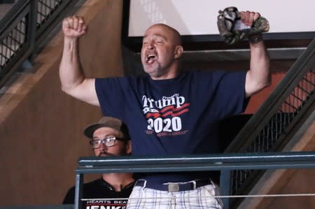 Trump supporter Dawson cheers after helping to eject a small group of protesters during a Trump campaign rally in Manchester, New Hampshire