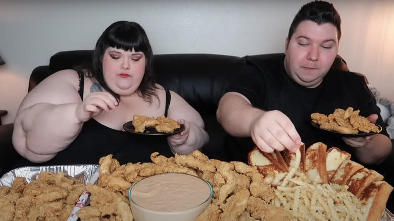 man and woman eating fried chicken