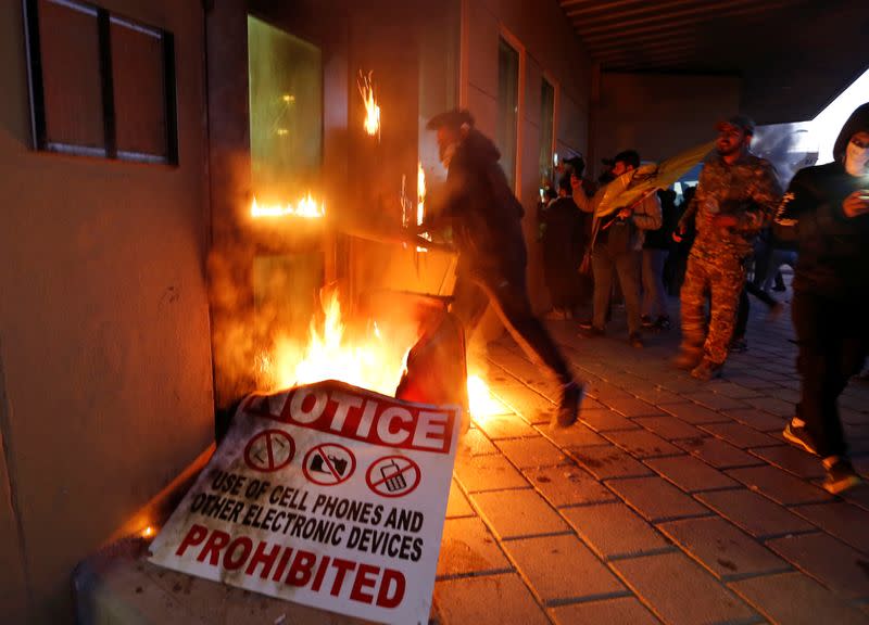 Protesters and militia fighters set fire to a reception room of the U.S. Embassy, during a protest to condemn air strikes on bases belonging to Hashd al-Shaabi, in Baghdad