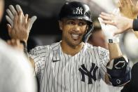 New York Yankees' Giancarlo Stanton celebrates with teammates after hitting a home run during the third inning of a baseball game against the Texas Rangers Tuesday, Sept. 21, 2021, in New York. (AP Photo/Frank Franklin II)