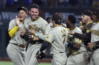 San Diego Padres starting pitcher Joe Musgrove, second from left, is mobbed by teammates after pitching a no-hitter against the Texas Rangers in a baseball game Friday, April 9, 2021, in Arlington, Texas. (AP Photo/Richard W. Rodriguez)