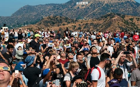 A crowd gathers in front of the Hollywood sign  - Credit: AP