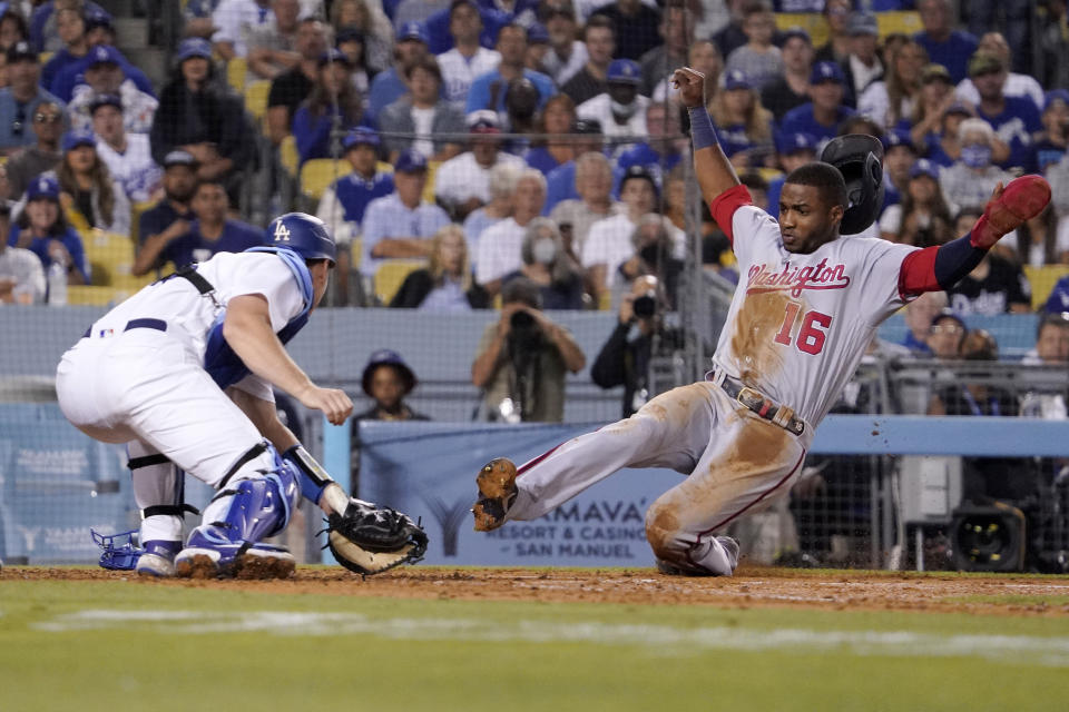 Los Angeles Dodgers catcher Will Smith, left, gets set to tag out Washington Nationals' Victor Robles as Robles tries to score on a single by Josh Bell during the fifth inning of a baseball game Tuesday, July 26, 2022, in Los Angeles. (AP Photo/Mark J. Terrill)
