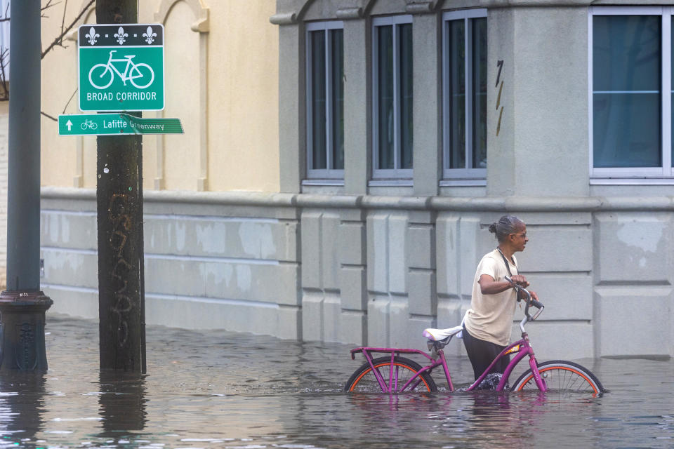 A cyclist pedals along a flooded street during a major thunderstorm, Wednesday, April 10, 2024, in New Orleans. (Chris Granger/The New Orleans Advocate via AP)