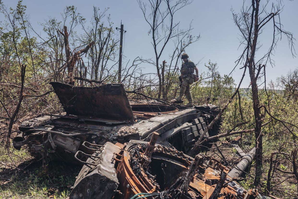 A Ukrainian soldier on a destroyed Russian tank