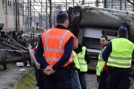 Rescuers and police officers stand next to the wreckage of a passenger train after it derailed in Kessel-Lo near Leuven, Belgium February 18, 2017. REUTERS/Eric Vidal