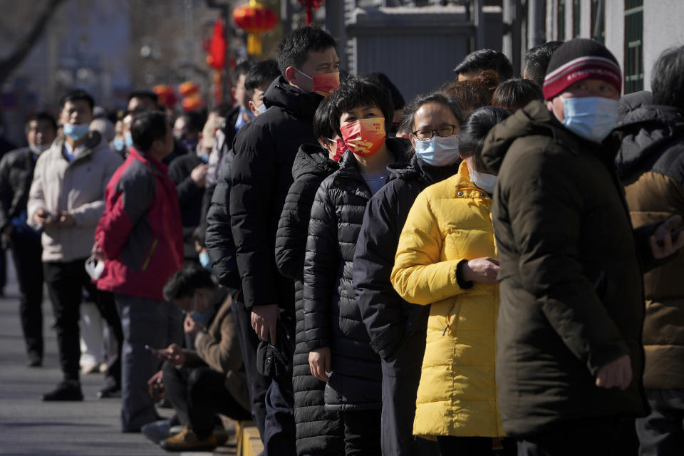 Residents wearing face masks to help protect from the coronavirus line up outside a COVID-19 test site in Beijing, Tuesday, Feb. 8, 2022. China has ordered inhabitants of the southern city of Baise to stay home and suspended transportation links amid a surge in COVID-19 cases at least partly linked to the omicron variant. (AP Photo/Andy Wong)