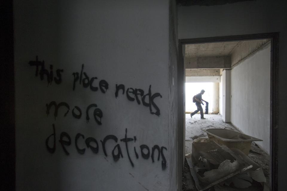 A visitor walks inside an abandoned building in Bangkok, Thailand. The abandoned building, known as Sathorn Unique, dubbed the 'ghost tower' was destined to become one of Bangkok's most luxurious residential addresses but construction was never completed as the Thai economy was hit during the 1997 Asian Financial Crisis. Now, many travellers visit and explore the 49-story skyscraper. (REUTERS/Athit Perawongmetha)