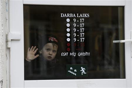 A boy looks through a shop window in Valka October 25, 2013. REUTERS/Ints Kalnins