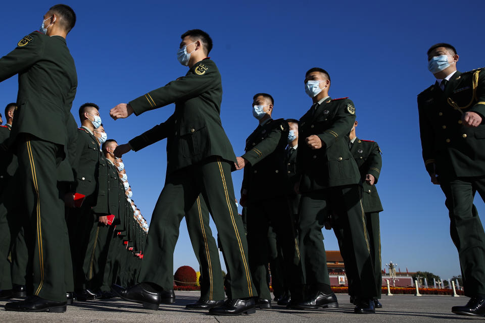 Chinese paramilitary policemen wearing face masks to help curb the spread of the coronavirus march to the Great Hall of the People to attend the commemorating conference on the 70th anniversary of China's entry into the 1950-53 Korean War, in Beijing Friday, Oct. 23, 2020. (AP Photo/Andy Wong)