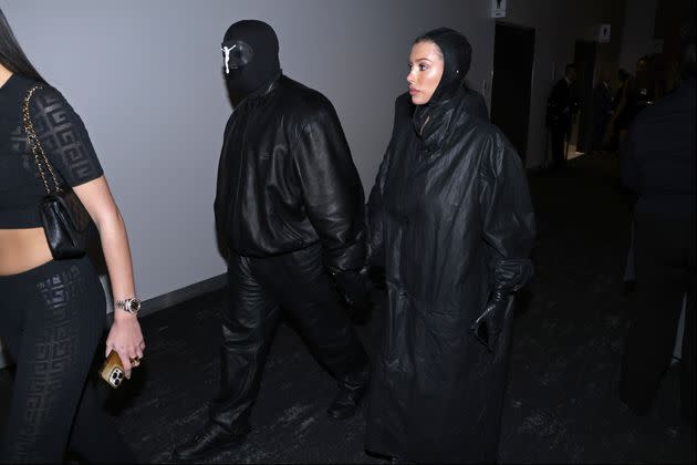 Ye, left, wears a crucifix mask and balaclava while at the big game with Bianca Censori.