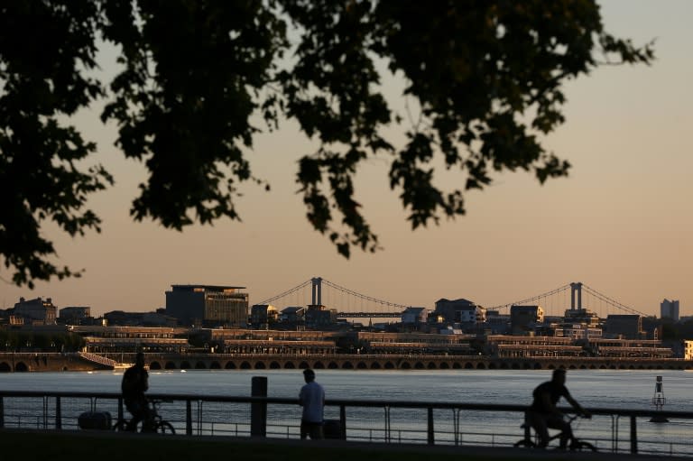 Des promeneurs au petit matin sur les quais à Bordeaux, avant la chaleur, le 21 août 2023 en Gironde (AFP - ROMAIN PERROCHEAU)