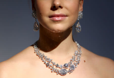 An assistant poses with Miroir de l'Amour, a pair of flawless diamond pear-shaped earrings and the diamond necklace Le Jardin d'Isabelle, during a sale preview at Christie's auction house in London, Britain October 20, 2016. REUTERS/Neil Hall/File Photo