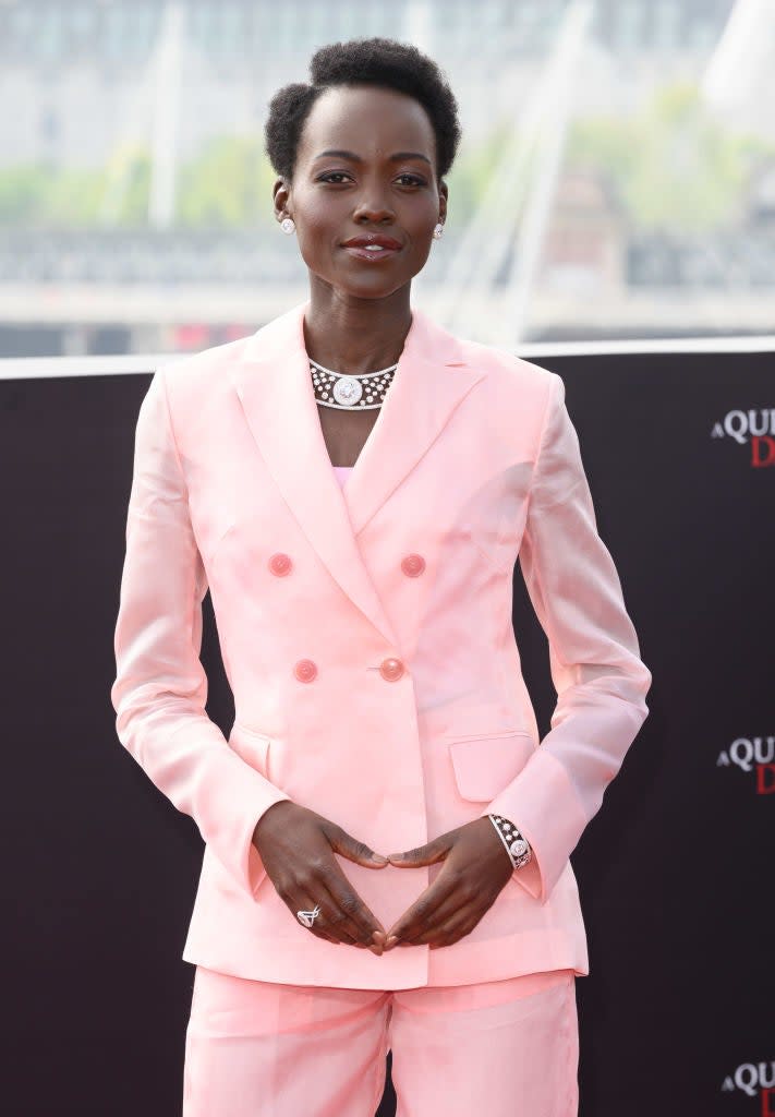 Lupita Nyong'o on the red carpet wearing a tailored double-breasted suit