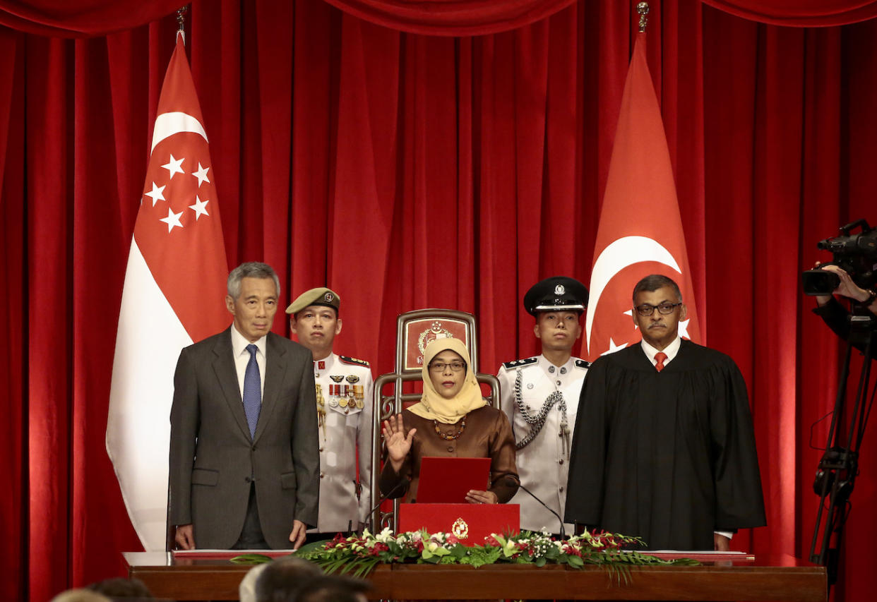 President-elect Halimah Yacob takes the oath of office while flanked by Singapore Prime Minister Lee Hsien Loong (L) and Chief Justice Sundaresh Menon (R) during the presidential inauguration ceremony at the Istana Presidential Palace in Singapore, 14 September 2017. (PHOTO: Wallace Woon/Pool Photo via AP)