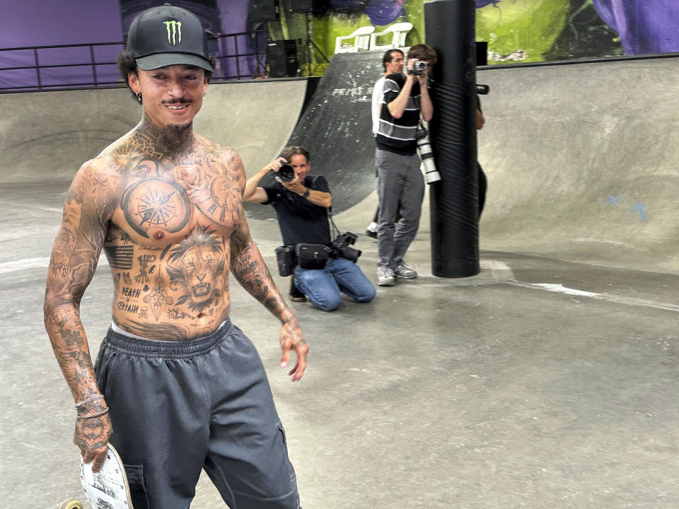 Nyjah Huston smiles as he walks past photographers at his private skate park in San Clemente, Calif., June 12, 2024. Huston is headed back to the Olympics with a determination to improve on his non-medal performance three years ago in Tokyo. (AP Photo/Greg Beacham)