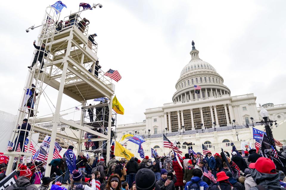 Supporters loyal to President Donald Trump clash with authorities before successfully breaching the Capitol building during a riot on the grounds, Wednesday, Jan. 6, 2021. A number of lawmakers and then the mob of protesters tried to overturn America's presidential election, undercutting the nation's democracy by attempting to keep Democrat Joe Biden from replacing Trump in the White House.