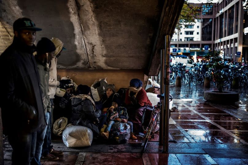 People prepare to sleep under stairs, on November 13, 2017 in a street of Lyon, central-eastern France, three days after having been expelled from a makeshift camp.