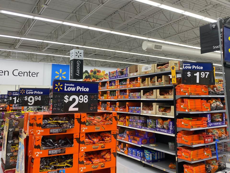 An aisle at walmart filled with candy and signs advertising discounts