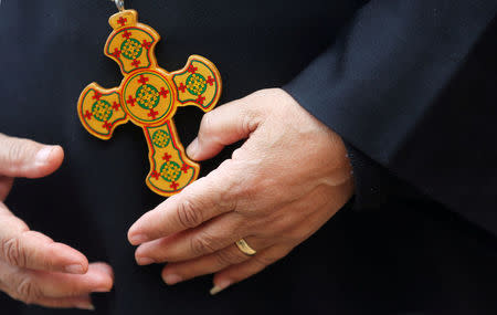 A priest who left with his family from Al-Arish city North Sinai’s Governorate capital after the escalation of a campaign targeting Christians by Islamic State militants last week, looks on and rest near cross at a youth guest house in Ismailia, northeast of Cairo, Egypt February 27, 2017. Picture taken February 27, 2017. REUTERS/Amr Abdallah Dalsh