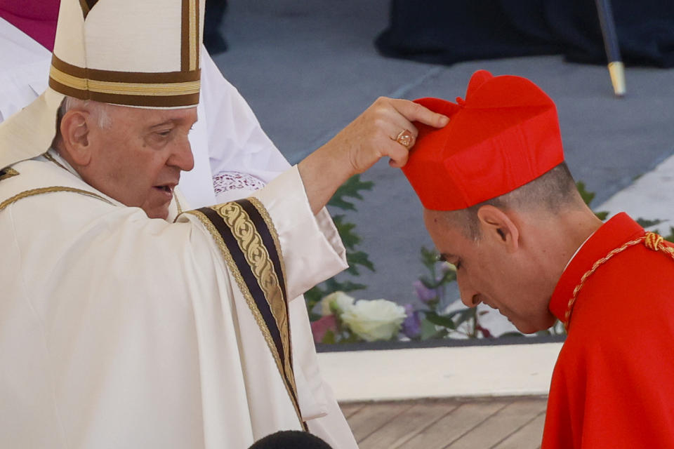 FILE - Newly elected Cardinal Víctor Manuel Fernández, Prefect of the Dicastery for the Doctrine of the Faith, right, receives his biretta from Pope Francis as he is elevated in St. Peter's Square at The Vatican, Saturday, Sept. 30, 2023. The Vatican’s new doctrine chief, already under fire from entire bishops conferences for his approval of blessings for same-sex couples, is raising eyebrows anew over a book he wrote as a young priest describing orgasms in graphic terms. (AP Photo/Riccardo De Luca, File)