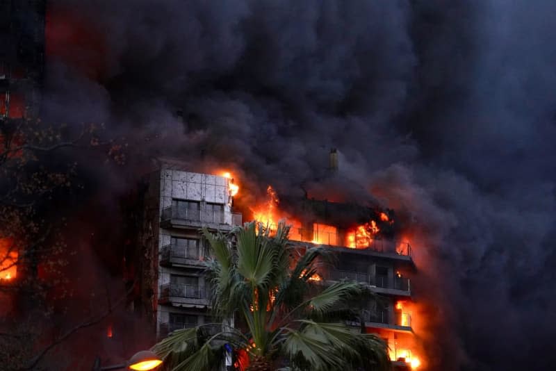 Smoke rises and flames blaze from a high-rise apartment building in the Campanar district. According to the emergency services, the fire broke out in an apartment on the fourth floor and spread rapidly. Eduardo Manzana/EUROPA PRESS/dpa