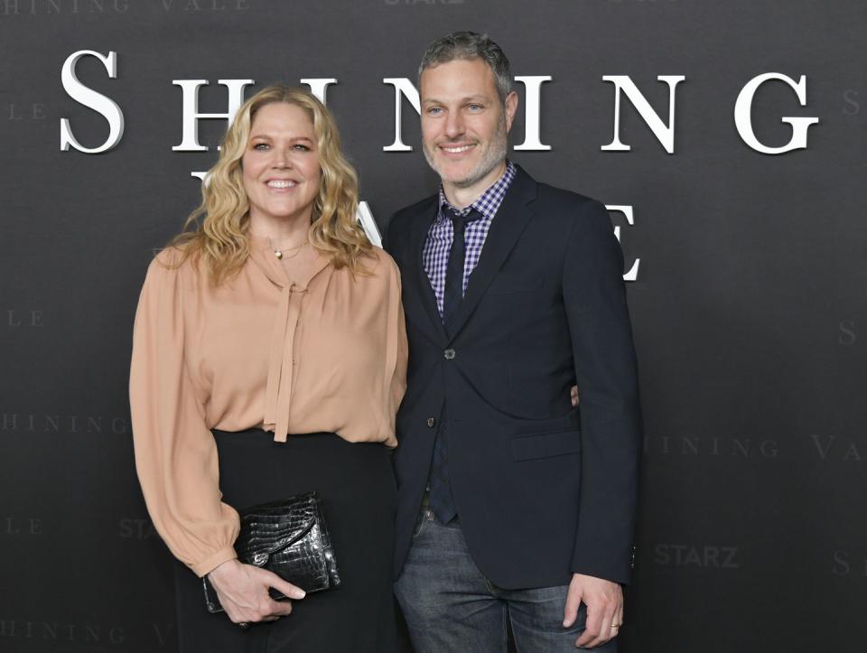 mary mccormack and michael morris standing in front of a black wall and smiling for a publicity photo
