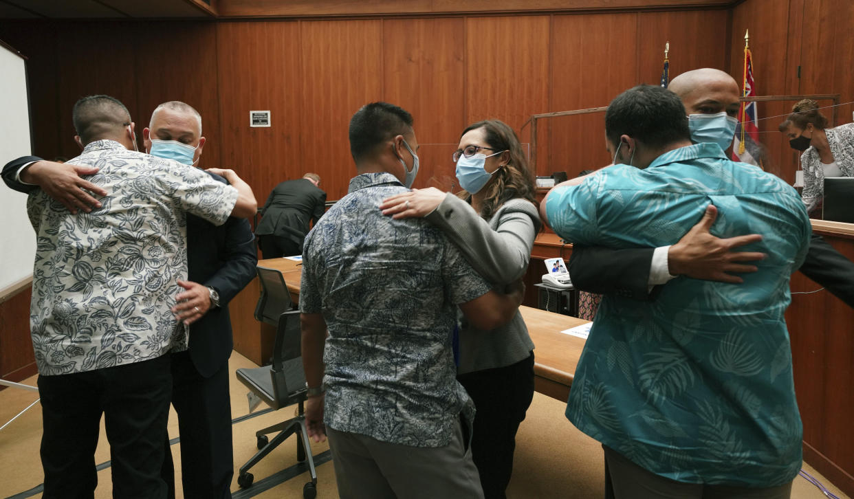 From left to right, defense attorney Richard H.S Sing, facing camera, embraces his client Geoffrey Thom, as attorney Crystal K. Glendon embraces her client Christopher Fredeluces and Thomas Otake embraces his client Zackary Ah Nee after Judge William Domingo rejected murder and attempted murder charges against the Honolulu Police officers in the fatal shooting of a teenager, preventing the case from going to trial, Wednesday, Aug. 18, 2021, at district court in Honolulu. (Cory Lum/Honolulu Civil Beat via AP, Pool)